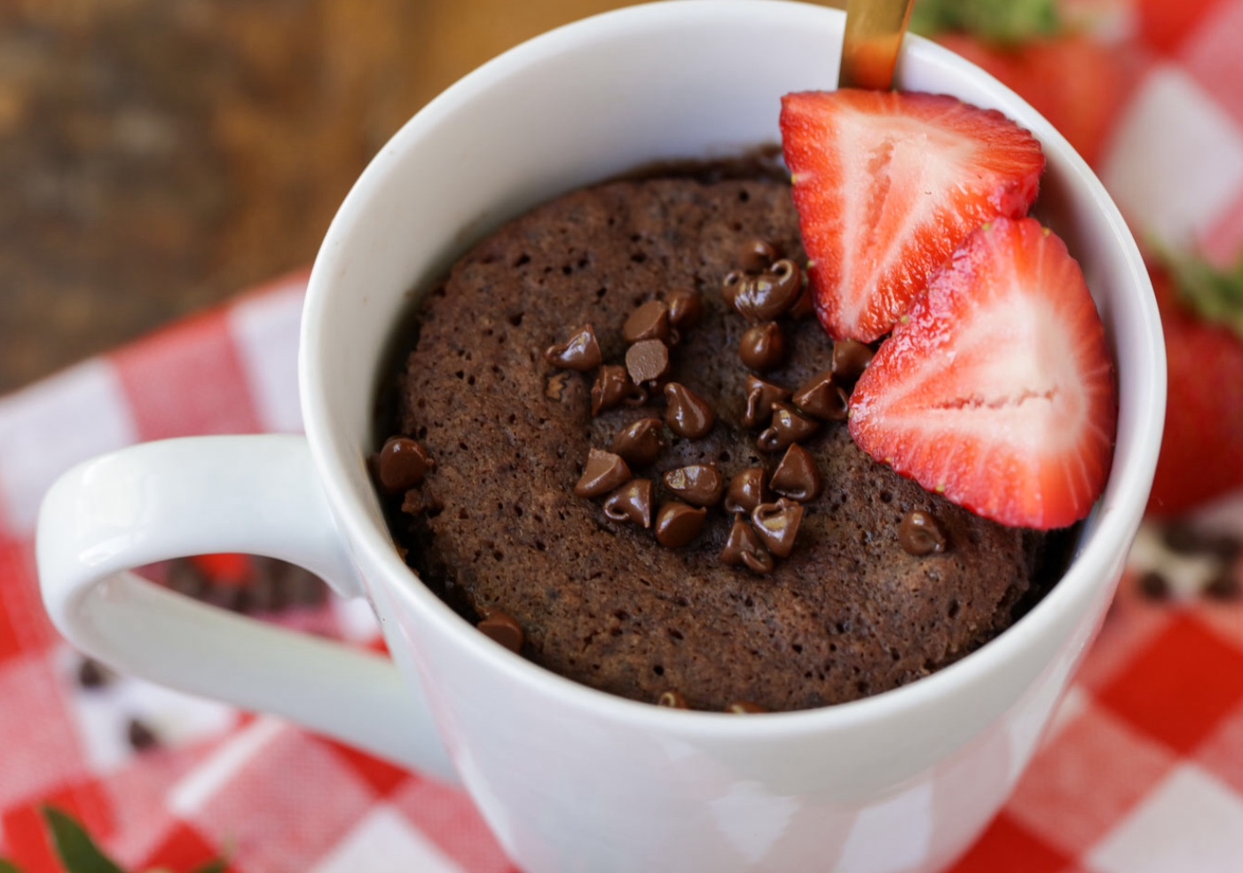 A cup of chocolate cake with strawberries on top.